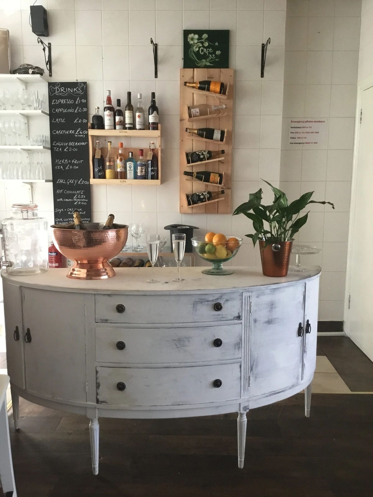 A painted white sideboard with drinks, wine rack and a chalkboard menu
